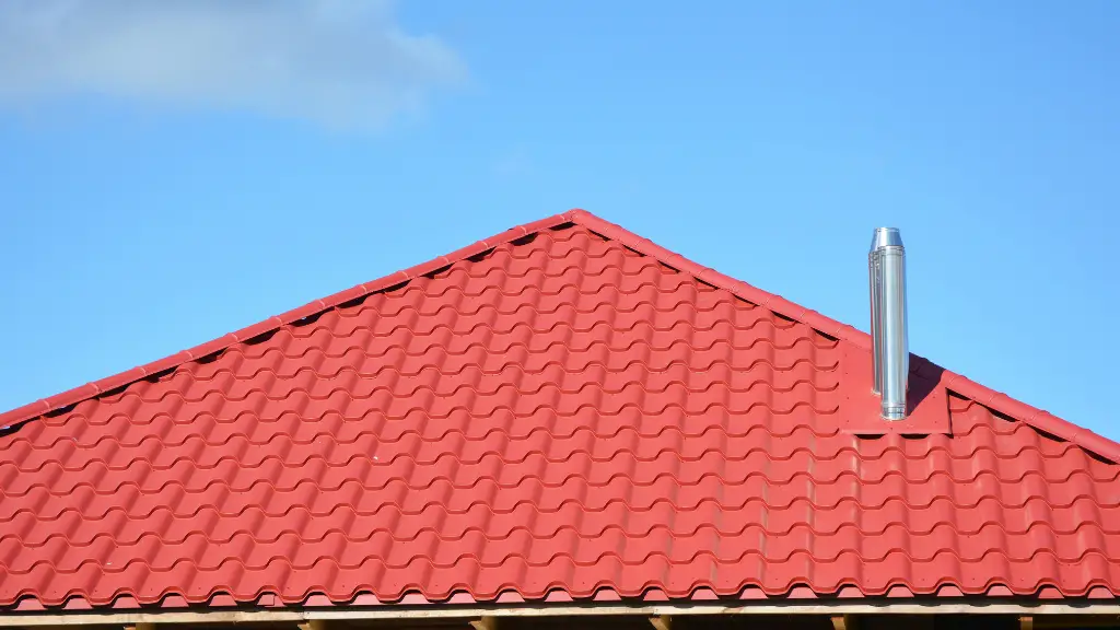 Red metal roofing construction. Metal modular coaxial chimney with red metal sheets house roof. Roofing Construction.
