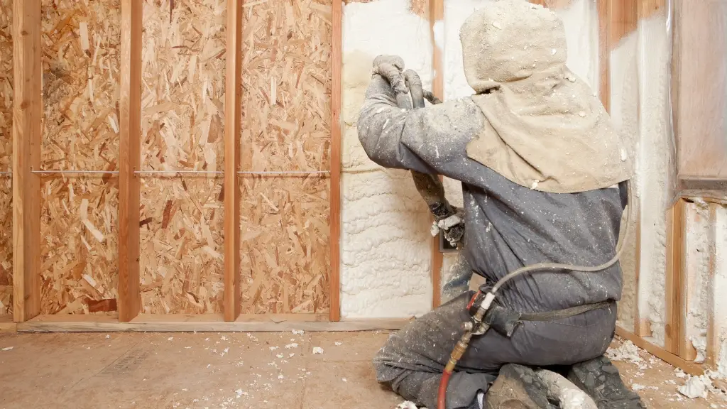 Worker Spraying Expandable Foam Insulation between Wall Studs